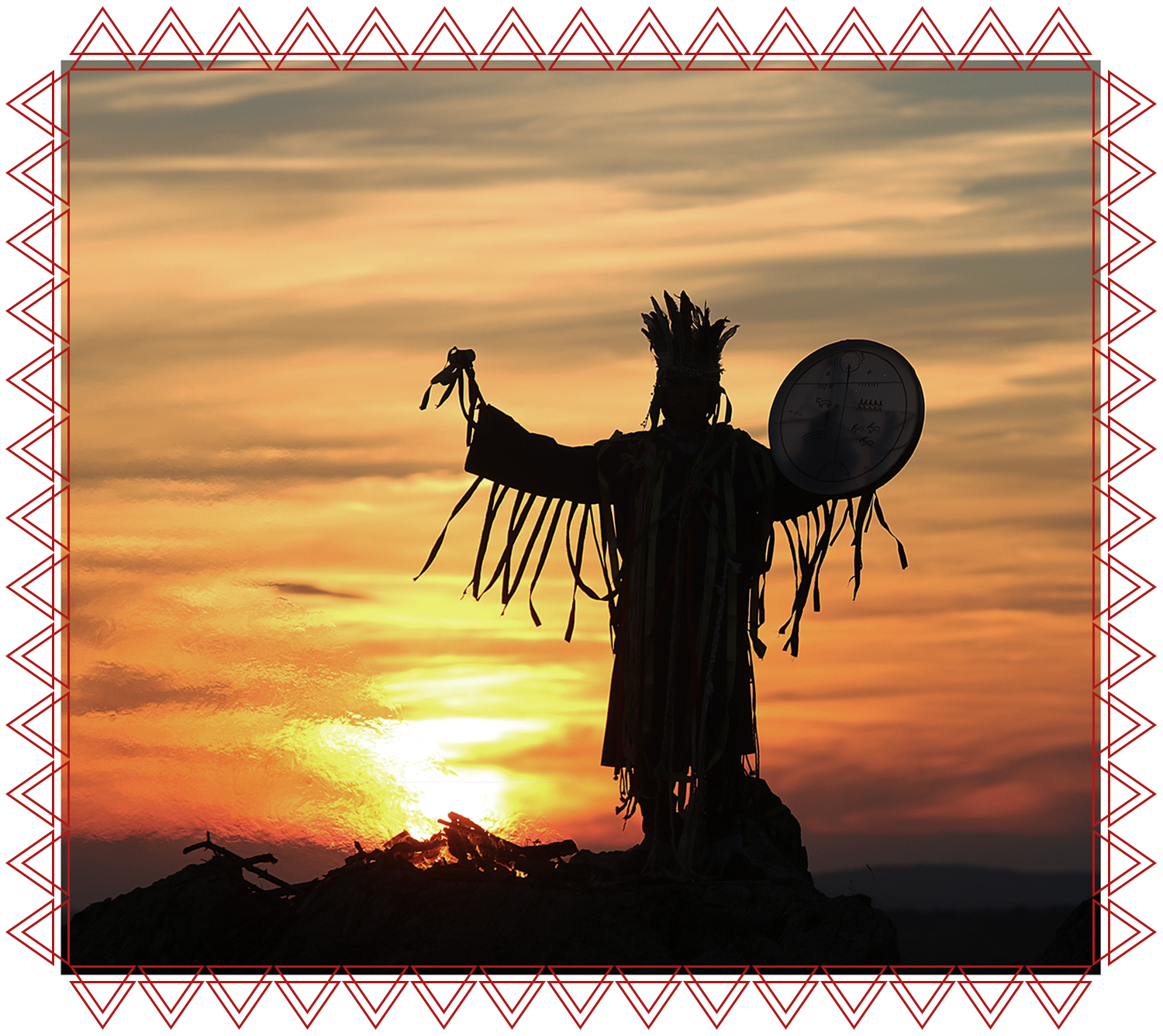 IACFS Schamanismus Akademie - Schamane mit Trommel tanzt vor Lagerfeuer bei Sonnenuntergang