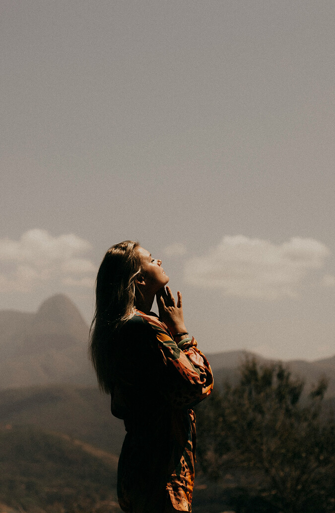 Frau schaut in Sonne, Landschaft im Hintergrund